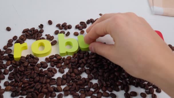 Zwarte koffiebonen zaad verspreid op tafel, donkere koffie robusta. Selectieve focus — Stockvideo