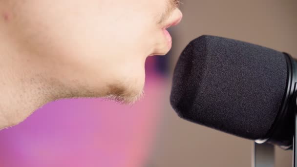 Man singing into a microphone. A spot of light, a musical concept. Selective focus — Stock videók