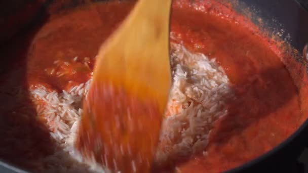 Jollof arroz em uma panela de ato de fritar cozinha. Um prato tradicional nigeriano de arroz, tomate e especiarias. — Vídeo de Stock
