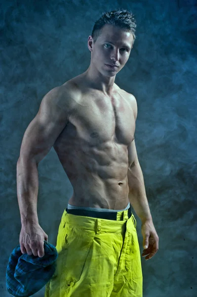 Muskulöser Mann in modischer Pose in Snowboardhose — Stockfoto