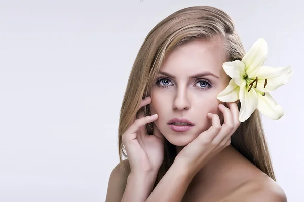 Volto di bellezza della giovane bella donna con fiore. Femmina. — Foto Stock