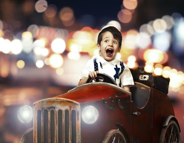 Uśmiech dziecka w samochodzie drewniane w nocy na ulicy — Zdjęcie stockowe