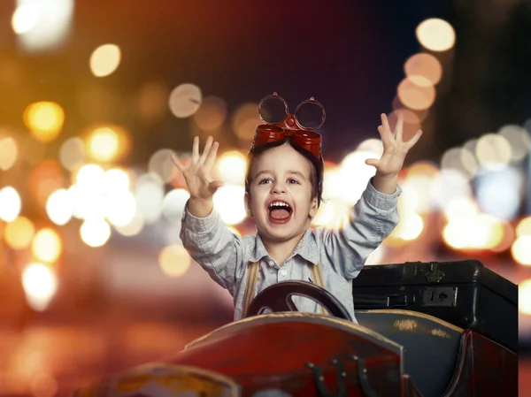 Sourire enfant en voiture en bois dans la nuit dans la rue — Photo