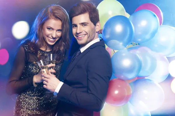 Casal sorrindo com copos de champanhe — Fotografia de Stock