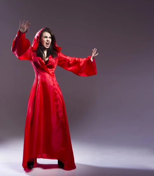 Elegante bruja joven en una ropa roja lanzó hechizo mágico — Foto de Stock