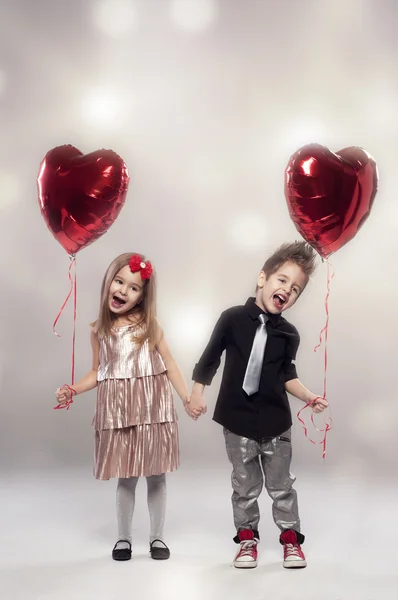 Happy kids with red heart balloon on a light background — Stock Photo, Image