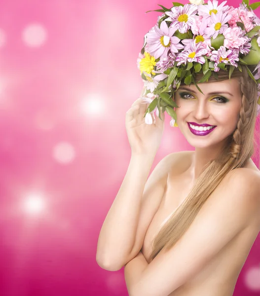 Belle femme souriante avec des fleurs de printemps et de gros cheveux — Photo