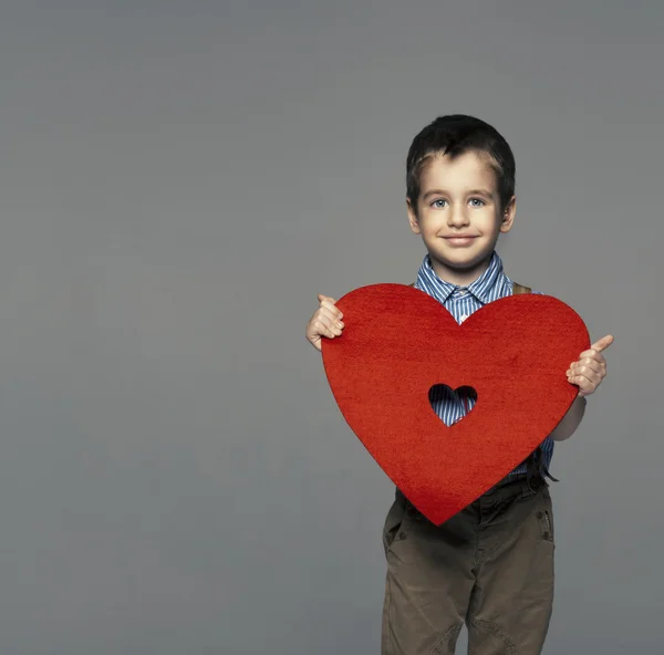 Retrato de um menino pequeno apresentando coração — Fotografia de Stock