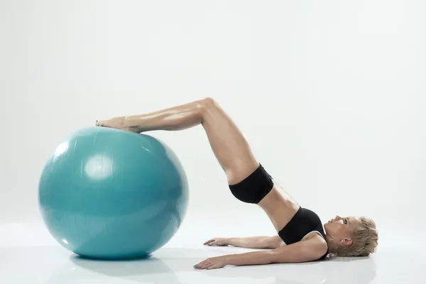 Una mujer caucásica ejercitando entrenamiento de pelota de fitness — Foto de Stock