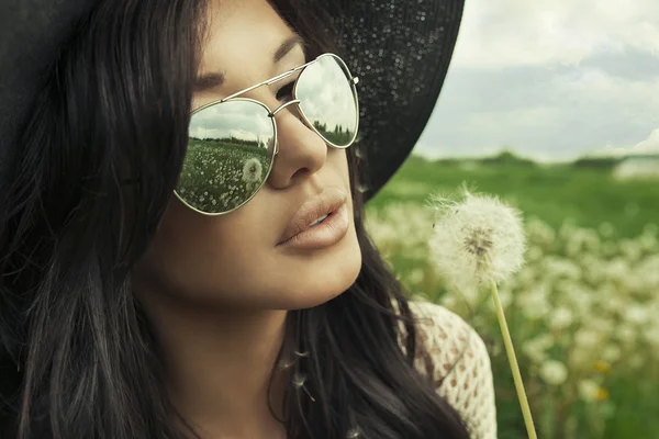 Woman blowing a dandelion — Stock Photo, Image