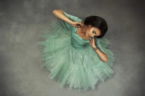 Elegant brunette in green dress posing in the studio — Stock Photo, Image