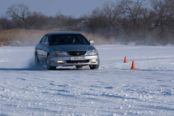 1月22日 俄罗斯 普里莫尔斯基边疆区 Spassk Dalny 一辆灰色的轿车在结冰的湖面上沿着雪地覆盖的公路行驶 背景是树木从左到右 阳光灿烂 — 图库照片