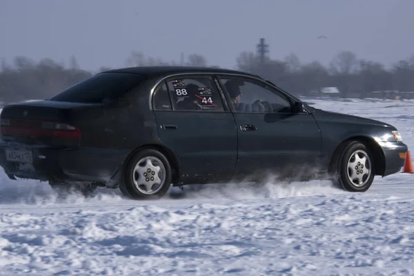 1月22日 2022年1月22日 俄罗斯普里莫尔斯基边疆区的Spassk Dalniy 一辆黑色轿车在结冰的湖面上开着一条被雪覆盖的公路 从左一直开到右 阳光灿烂 — 图库照片
