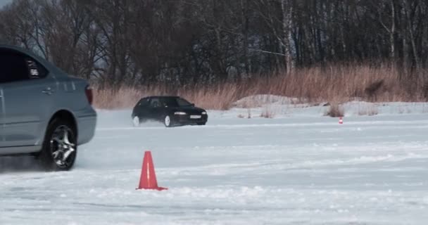 ロシア プリモルスキー地方のSpassk Dalny 2022年1月22日 木々の背景に凍結した湖の雪に覆われた高速道路に沿って車が運転し 車輪の下から雪が散乱し 晴れた日 — ストック動画