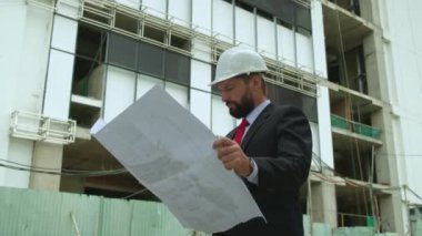 Bir mühendis, inşaat alanındaki müteahhit çizimleri kontrol ediyor. Çok katlı binaların hangi aşamasında Hi-Rise binaları var?