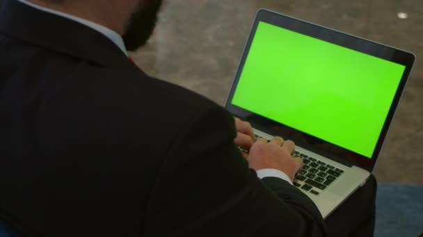 Homme d'affaires travaillant sur un ordinateur portable dans le hall du bureau. Dactylographie professionnelle sur clavier d'ordinateur portable sur le lieu de travail dans le bureau, les mains de l'homme d'affaires travaillant sur ordinateur portable à écran vert à l'intérieur. — Video