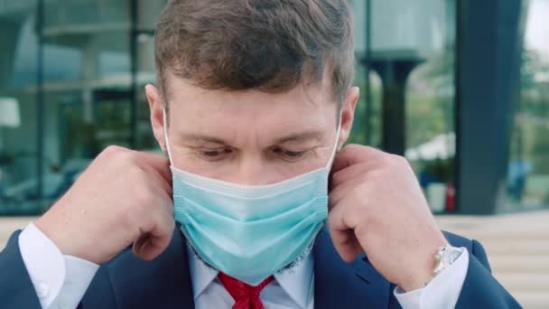 İş elbisesi giymiş kıdemli bir mühendisin portresi, kameraya bakıyor, Coronavirus COVID 19 salgınından ya da salgınından sonra yüzündeki koruyucu maskeyi çıkarıyor.. — Stok video