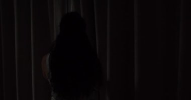 Yatak odasında perdeleri açan genç bir kadın. - Yakın çekim. Femele eller sabah pencerenin perdesini açar. Eller sabah ışığı için pencere perdesini çeker. Yavaş çekim.