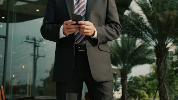 Empresário de meia-idade em roupas de luxo usando telefone celular para mensagens de texto durante o caminho para o escritório no distrito financeiro na cidade metropolitana, bem sucedido masculino orgulhoso ceo sorrindo durante mensagens celulares. — Vídeo de Stock