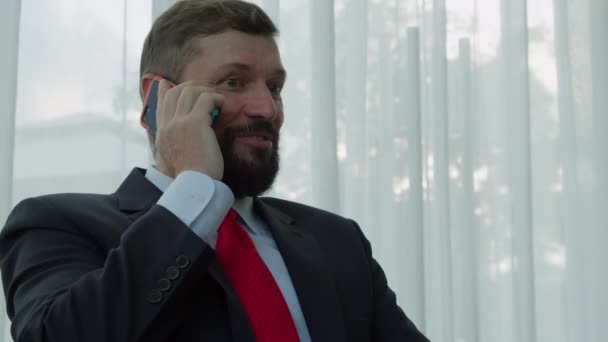 비싼 양복을 입고 사무실에서 전화 통화를 하고 협상에 만족 해 하는 행복 한 사업가의 모습, 그 가승리 한 것을 보여 주면서 주먹을 위로 치켜들고 있는 모습. — 비디오