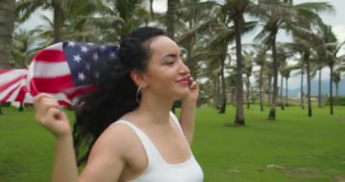 Vatanseverlik, bağımsızlık günü ve tatil konsepti. Yaz mevsiminde ulusal Amerikan bayrağıyla mayolu mutlu bir genç kadın..