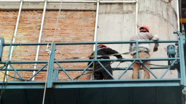 Metal yapıları kaynak yapan endüstriyel işçiler, inşaat alanındaki yeni bir binaya çelik kiriş döşeyen erkek kaynakçılar. Kaynakçı çalışıyor. Kıvılcımlar kaynak çeliği gibi uçar. inşaatçı