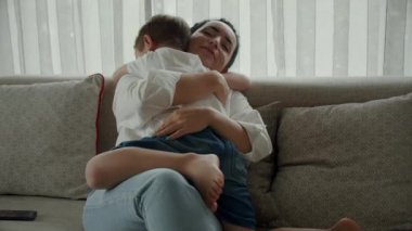 Yakın çekim annesi, krebkos 'un küçük oğluna şefkatle sarılıyor. Krebkos' un oğlu, genç annesine sarılıyor, kollarının arasından çıkmasına izin vermiyor, sevgisini gösteriyor. Çocuk, aile, annelik, çocukluk kavramı..