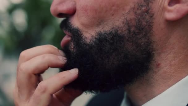 Close-up of a mans face, portrait of an elderly man with a beard, close-up of the lower part of the face, talking head of a business man standing in the street, looking at the camera, slow motion. — Stock Video