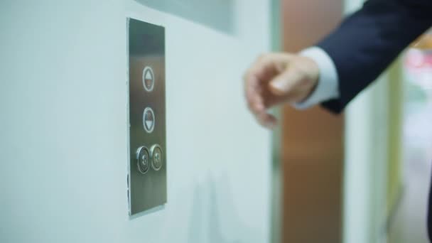 Homem de negócios apertando o botão vermelho para chamar o elevador no escritório de negócios moderno. Gerente de negócios entrando no elevador no corredor de apartamento moderno — Vídeo de Stock