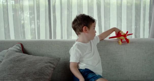 Lindo Niño Preescolar Jugando Casa Sofá Con Avión Juguete Lindo — Vídeo de stock