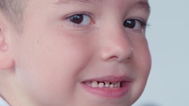 Молочный зуб во рту десятилетнего мальчика, он раскачивает его пальцем, закрывая вид на открытый рот. Смена зубов у подростка. Стоматология, стоматология для детей — стоковое видео
