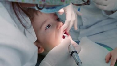 Diş hekimliği, kadın diş hekimi klinikteki küçük çocuk hastasına diş tedavisi. Kadın profesyonel doktor Stomatolog iş başında. Konsept Diş Denetimi.