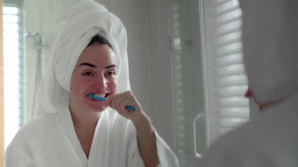 Conceito de Cuidado Oral. Close up Mulher caucasiana Retrato com dente branco olhando espelho isolado em casa. Menina adolescente bonito escovar os dentes no banheiro e sorrindo. Estilo de vida. — Vídeo de Stock
