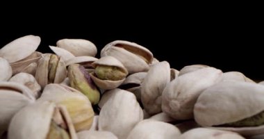 Makro mercek, fındık fıstığının siyah ve sarı arkaplandaki güzel ışıkta çok yakın çekim makrosu, fıstıklı kameraya çarpıyor.