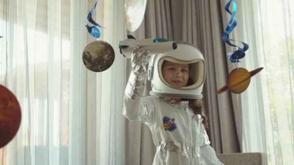 Kreativer Weltraumträumer. Fantasie-Kind-Astronautin fliegt im Raumschiff.Spacewoman Form des Weltraum-Helden im Anzug Hummel Astronautin erobert den Weltraum in ihrem Kinderzimmer, Innenraum mit Planeten gehängt.