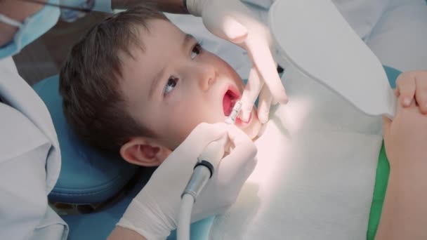 Zahnärztin in der Zahnarztpraxis, Zahnärztin, die Zähne eines kleinen Jungen behandelt Patientin in der Klinik. Berufsärztliche Stomatologin bei der Arbeit. Konzept Dental Check Up. — Stockvideo