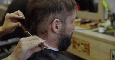 Profesyonel berber, müşteri sakalını ustura ile tıraş eder. Berber dükkanında eski moda bıçakla kesilmiş bir sakal. Sakalını kuaförde kestirecek yakışıklı bir adam..