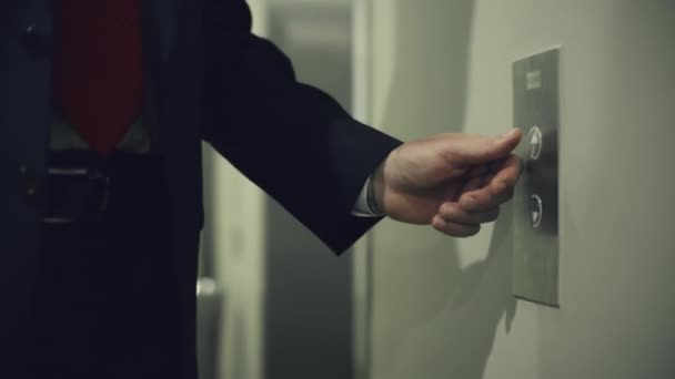 Бизнесмен нажимает красную кнопку для вызова лифта в современном бизнес-офисе. Бизнес-менеджер входит в лифт в современном жилом коридоре. — стоковое видео