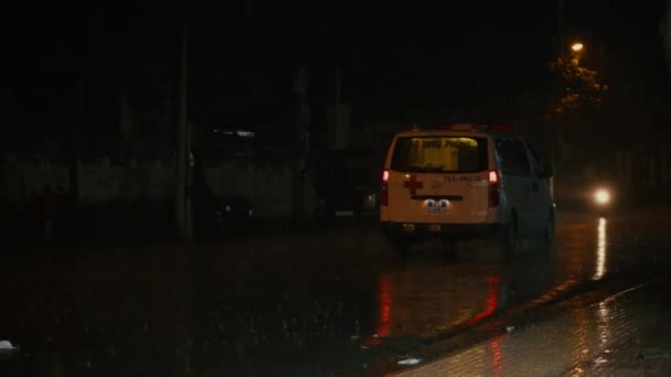 Una ambulancia covid que se mueve con sirenas con un estroboscopio de trabajo y una señal de llamada de emergencia en la calle de la ciudad por la noche en caso de fuertes lluvias se precipitan a la llamada.Provincia, Vietnam, 30 de septiembre de 2021 — Vídeo de stock