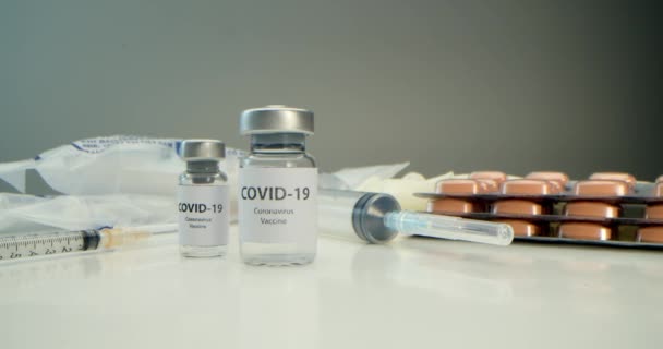 Vaccine against COVID-19, an ampoule with a vaccine against coronavirus and various syringes nearby, medical instruments, a protective mask, medicines, pills have been developed,SARS-COV-2 — Vídeo de Stock
