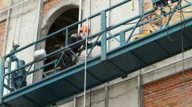 Metal yapıları kaynak yapan endüstriyel işçiler, kaynakçı erkek işçi inşaat alanındaki yeni binanın çelik kiriş yapısını lehimliyor. Kaynakçı çalışıyor. Kıvılcımlar bir kaynakçının çeliği kaynak yapması gibi uçar. inşaatçı