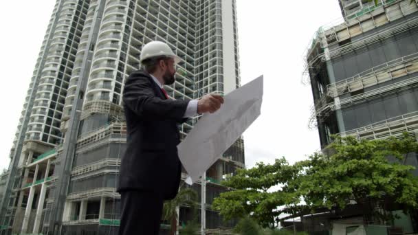 Mühendis, inşaat alanındaki müteahhit çok katlı binaların çizimlerini ne aşamada kontrol ediyor.. — Stok video