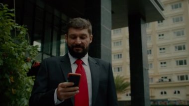 Sokakta telefonuna mesaj atan bir iş adamı. Bir metropolün finans bölgesinde lüks giysiler içinde ciddi bir orta yaşlı işadamı görüşmeler için cep telefonu kullanıyor. 4