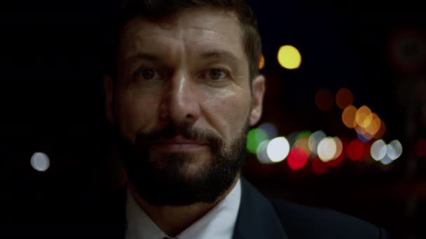 Portrait of a Successful male in an expensive suit, a handsome bearded senior businessman in the evening stands on the streets of the city next to a business building and looks at the camera. — стоковое видео