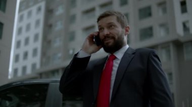 Sokakta bir adam cep telefonuyla konuşuyor. Bir metropolün finans bölgesinde lüks giysiler içinde ciddi bir orta yaşlı işadamı görüşmeler için cep telefonu kullanıyor. 4K