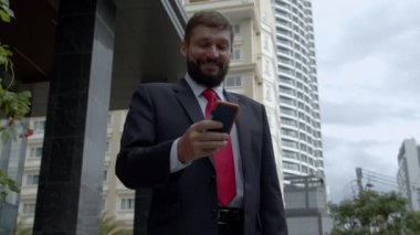 Sokakta telefonuna mesaj atan bir iş adamı. Bir metropolün finans bölgesinde lüks giysiler içinde ciddi bir orta yaşlı işadamı görüşmeler için cep telefonu kullanıyor. 4