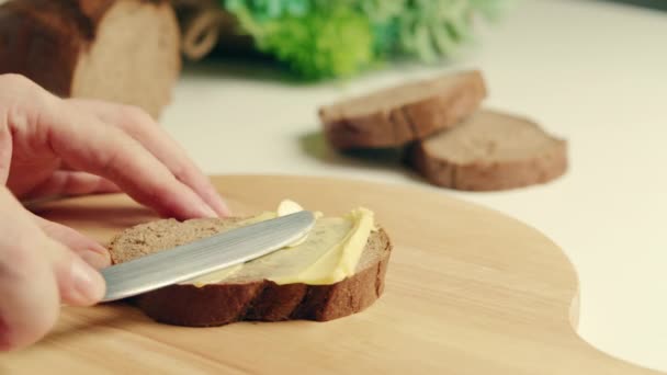 Carboidrati, concetto di grasso.Spalmare il burro biologico sul pane. Burro morbido spalmato su fetta di pane di pasta madre. — Video Stock