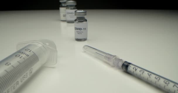 Er is een vaccin tegen COVID-19 ontwikkeld, een ampul met een vaccin tegen het coronavirus en een insulinespuit ernaast, kant-en-klare injectiekit voor gezondheidswerkers en mensen met een verhoogd risico. — Stockvideo