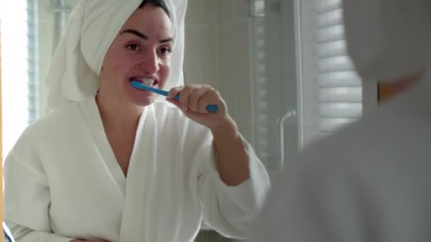 Oral Care Concept. Close up Portrait caucasian woman with white tooth looking at mirror isolated at home. Cute young teenage girl brushing teeth in bathroom and smiling. Lifestyle. — Stock Video
