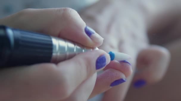 Манікюрник видаляє фіолетовий лак для нігтів на руках. манікюрний процес вдома. Видалення лаку за допомогою різака для нігтів . — стокове відео
